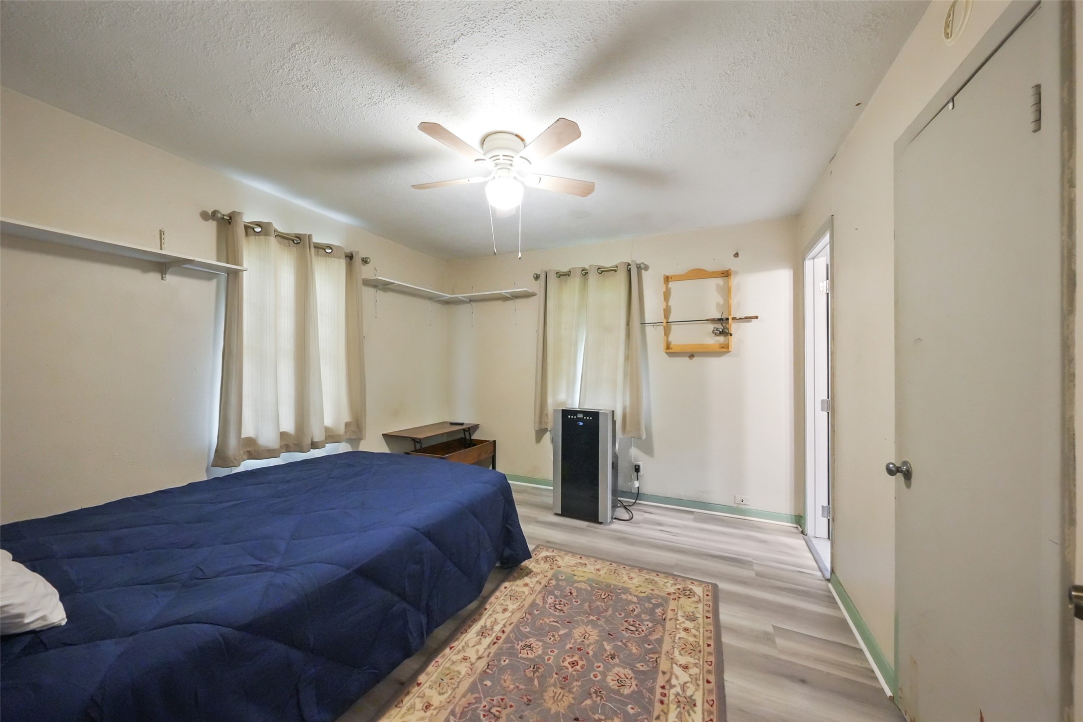 6387 Oak Knoll Road Montgomery, TX 77316 - Photo 15 of 30 a spacious bedroom with a large bed and a chandelier