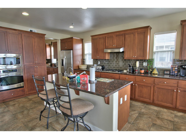 127 Fourth Street Spreckels, CA 93962 - Photo 2 of 20 a kitchen with stainless steel appliances granite countertop a table chairs and a refrigerator