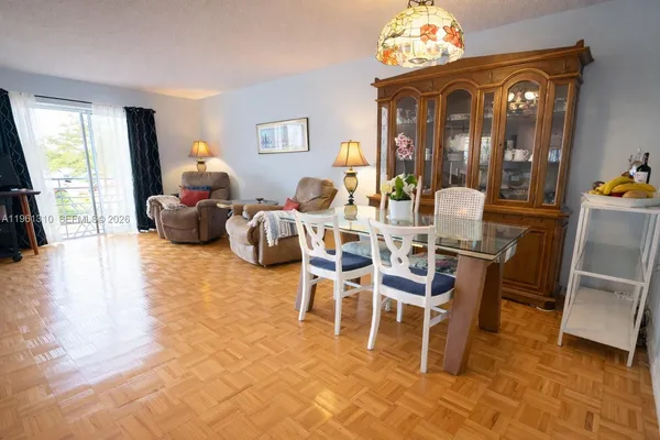 a dining room with furniture a flat screen tv and a chandelier