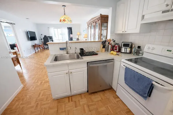 a kitchen with white cabinets and sink