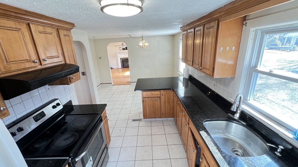 2 Carpenter Road Lynnfield, MA 01940 - Photo 7 of 20 a kitchen with granite countertop a stove a sink and a microwave