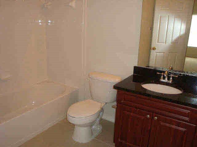 3725 Conroy Road, Unit 2135 Orlando, FL 32839 - Photo 7 of 14 a bathroom with a granite countertop sink a toilet and a mirror