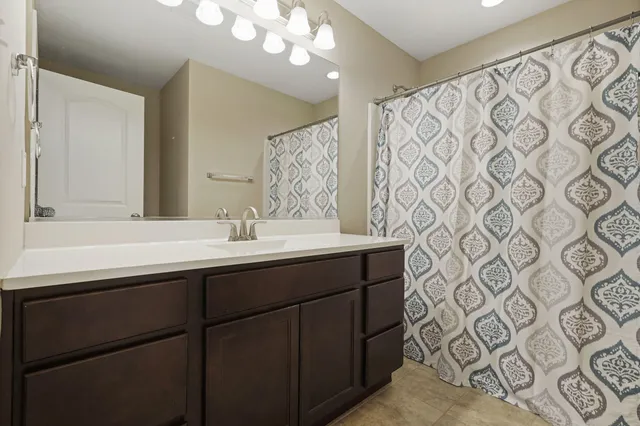a bathroom with a sink mirror and a shower