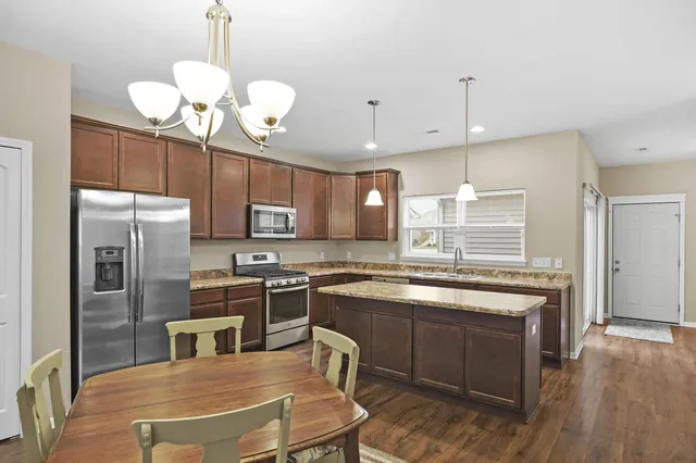 a kitchen with cabinets a counter space stainless steel appliances and wooden floor