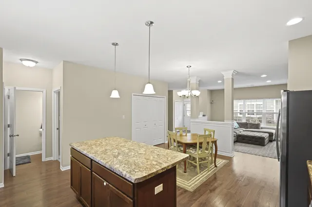 a living room with kitchen island a table and chairs