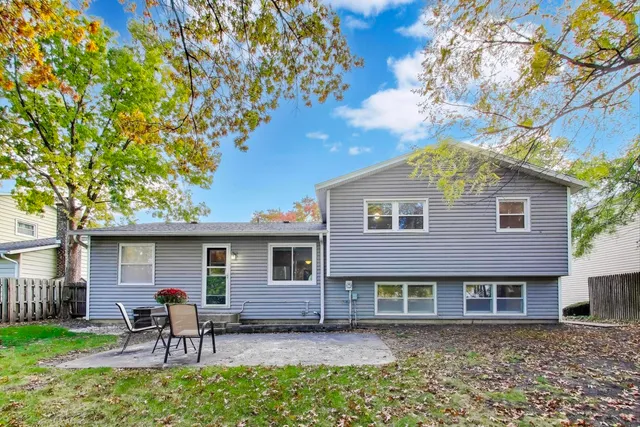 a backyard of a house with yard table and chairs