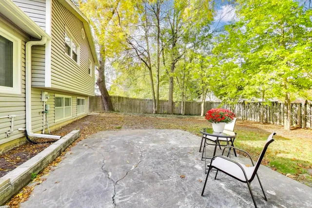 a backyard of a house with table and chairs