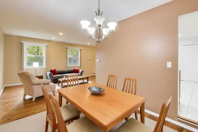 a view of a dining room with furniture a chandelier and wooden floor
