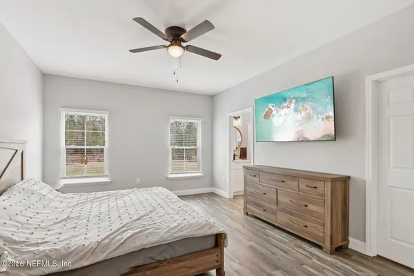 a bedroom with a bed a dresser and a window