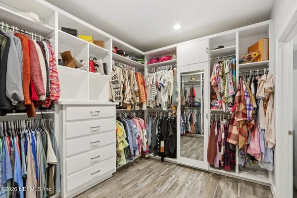 a view of walk in closet with clothes and shoes