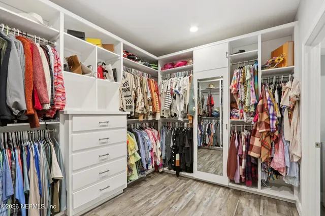 a view of walk in closet with clothes and shoes