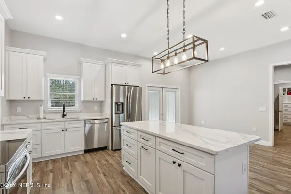 a kitchen with white cabinets and a sink