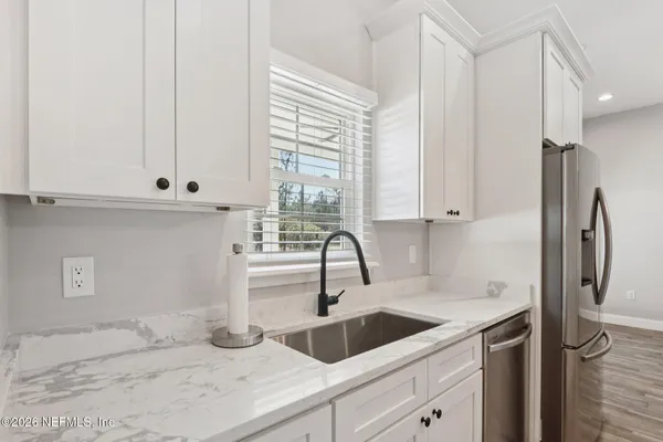 a large living room with stainless steel appliances kitchen island granite countertop furniture and a flat screen tv