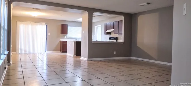 a view of a hallway with wooden floor and a living room