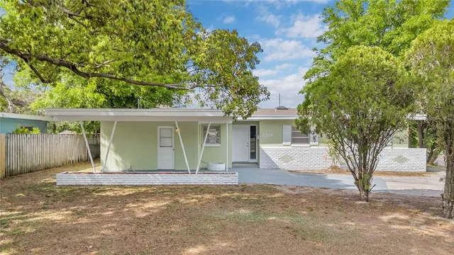a front view of house with yard and trees around
