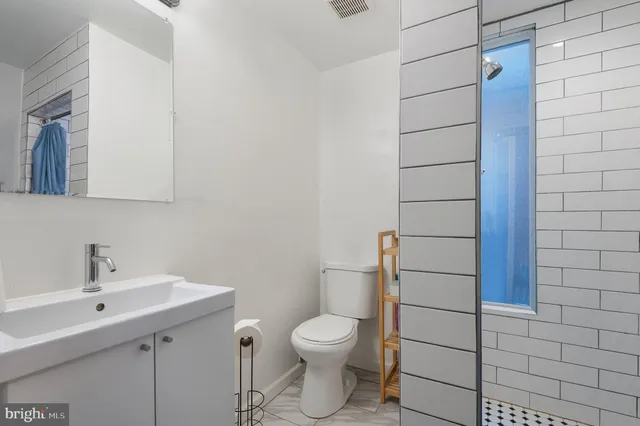 a bathroom with a toilet a sink and mirror