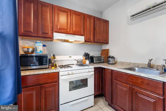 a kitchen with stainless steel appliances granite countertop a stove a sink dishwasher and cabinets with wooden floor