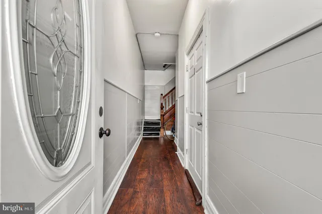 a view of a hallway with wooden floor and staircase