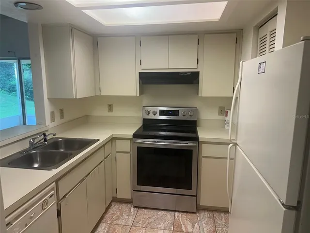 a kitchen with refrigerator sink and cabinets