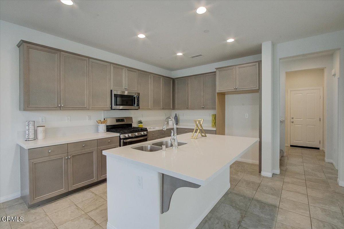 182 Stonegate Road Camarillo, CA 93010 - Photo 11 of 41 a kitchen with a sink a stove and refrigerator