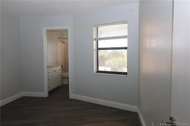 an empty room with wooden floor and a window