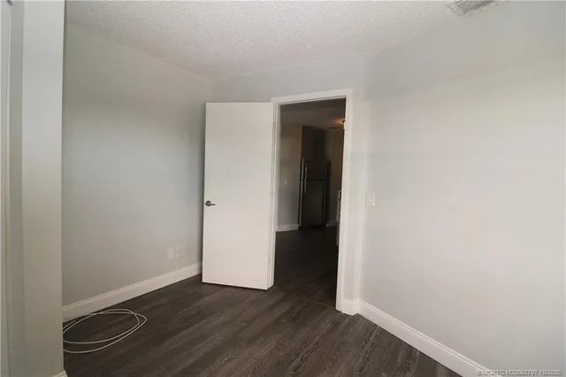 a view of an empty room with closet and a window