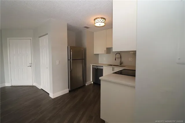 a kitchen with a refrigerator and a sink