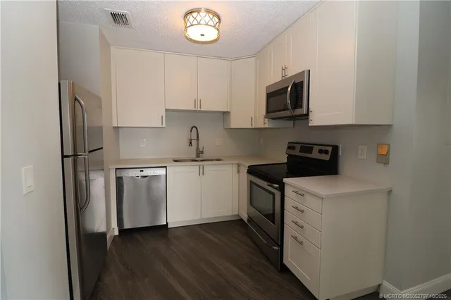 a kitchen with cabinets stainless steel appliances and a counter space