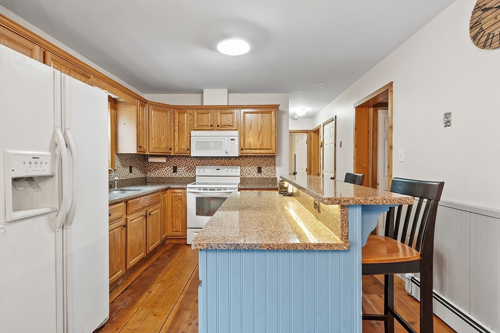 32 East Rindge Road Ashburnham, MA 01430 - Photo 6 of 31 a kitchen with stainless steel appliances granite countertop a stove a sink a microwave a dining table and chairs