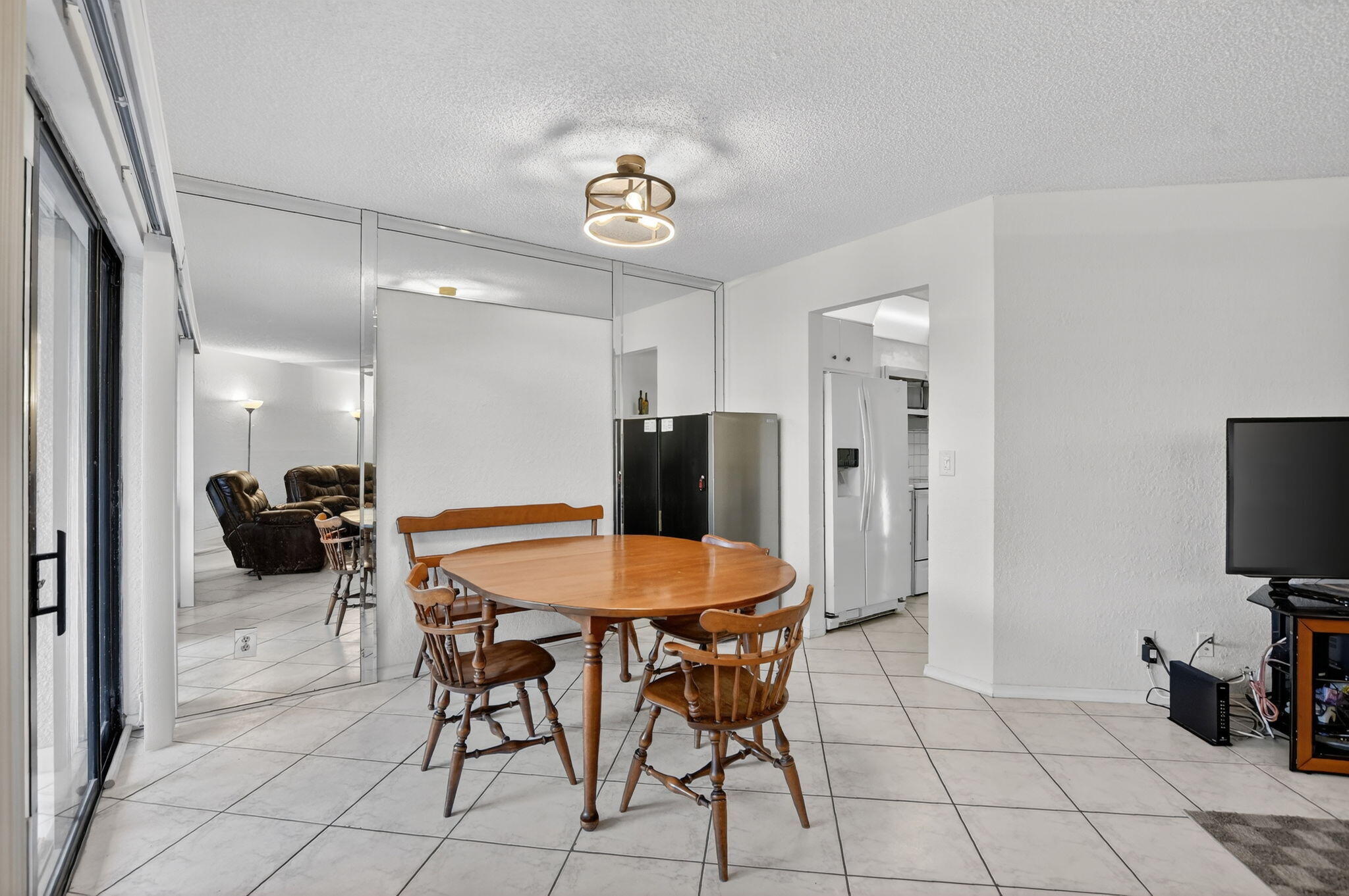 5650 Camino Del Sol, Unit 106 Boca Raton, FL 33433 - Photo 11 of 49 a dining room with furniture and a flat screen tv