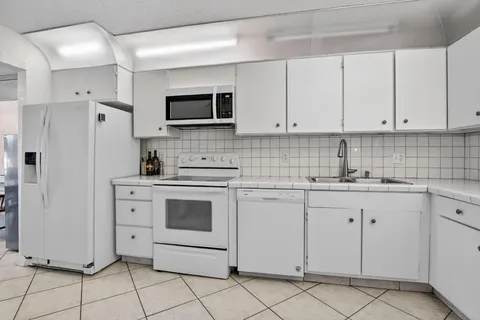 a kitchen with white cabinets stainless steel appliances and sink