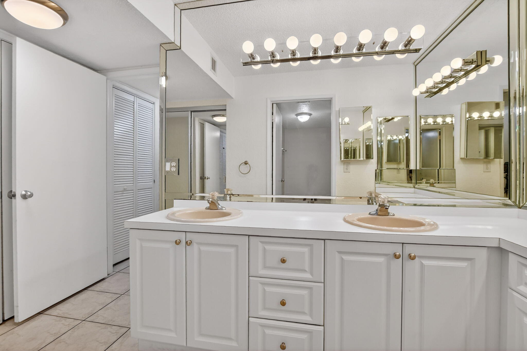 5650 Camino Del Sol, Unit 106 Boca Raton, FL 33433 - Photo 21 of 49 a bathroom with double sink and a mirror