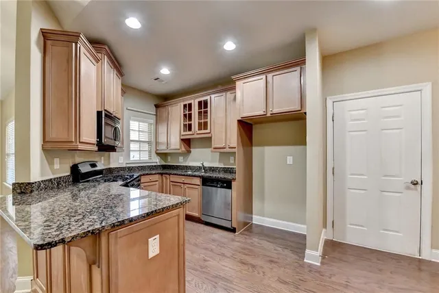 a kitchen with stainless steel appliances granite countertop a stove a sink and a microwave
