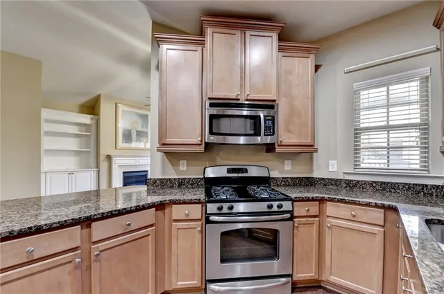 a kitchen with stainless steel appliances granite countertop a stove sink and cabinets