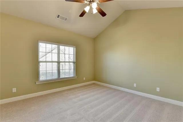 a view of an empty room and chandelier fan