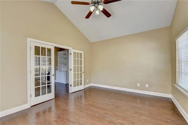 an empty room with windows and fan