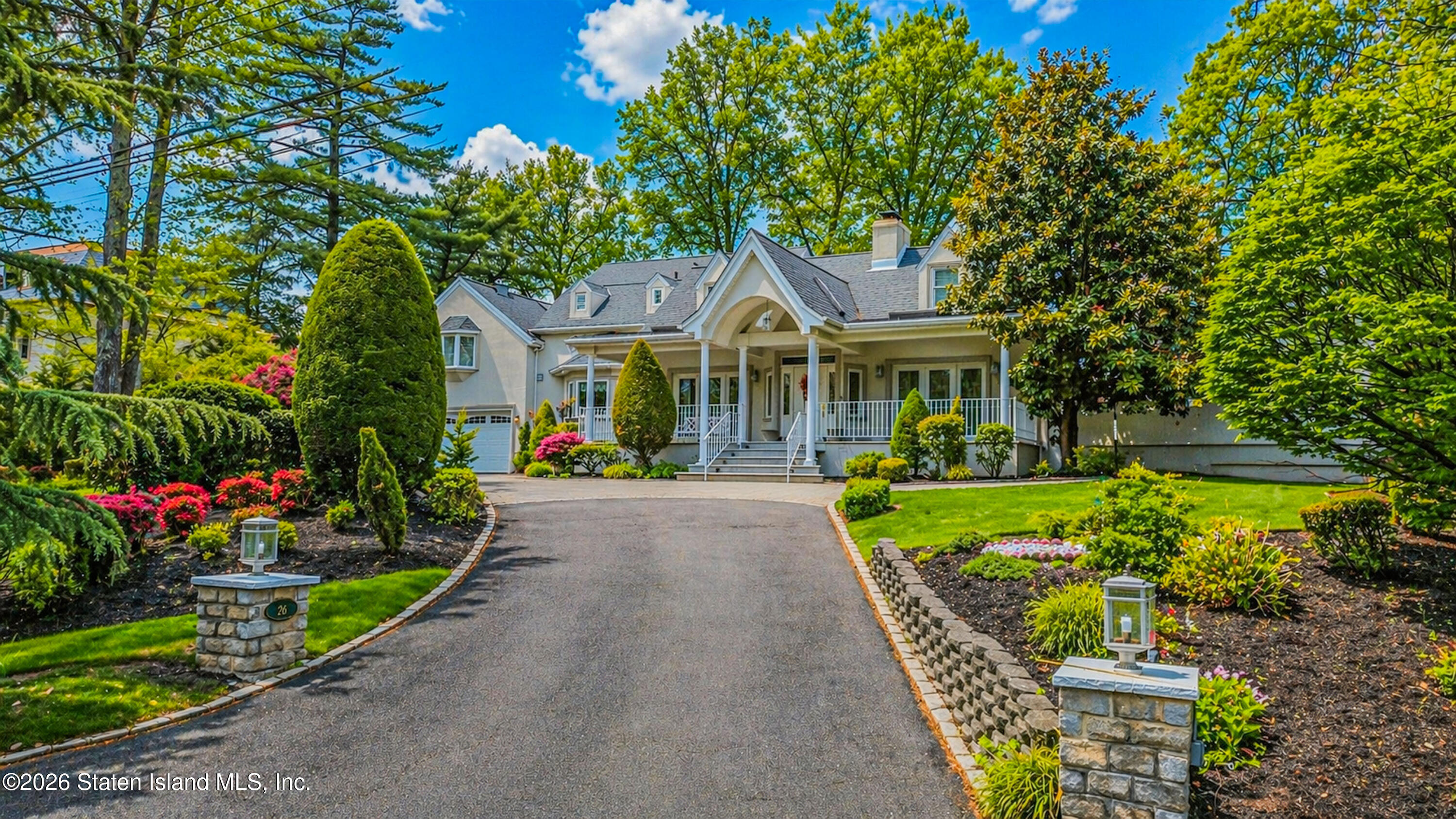 a front view of a house with a yard and fountain