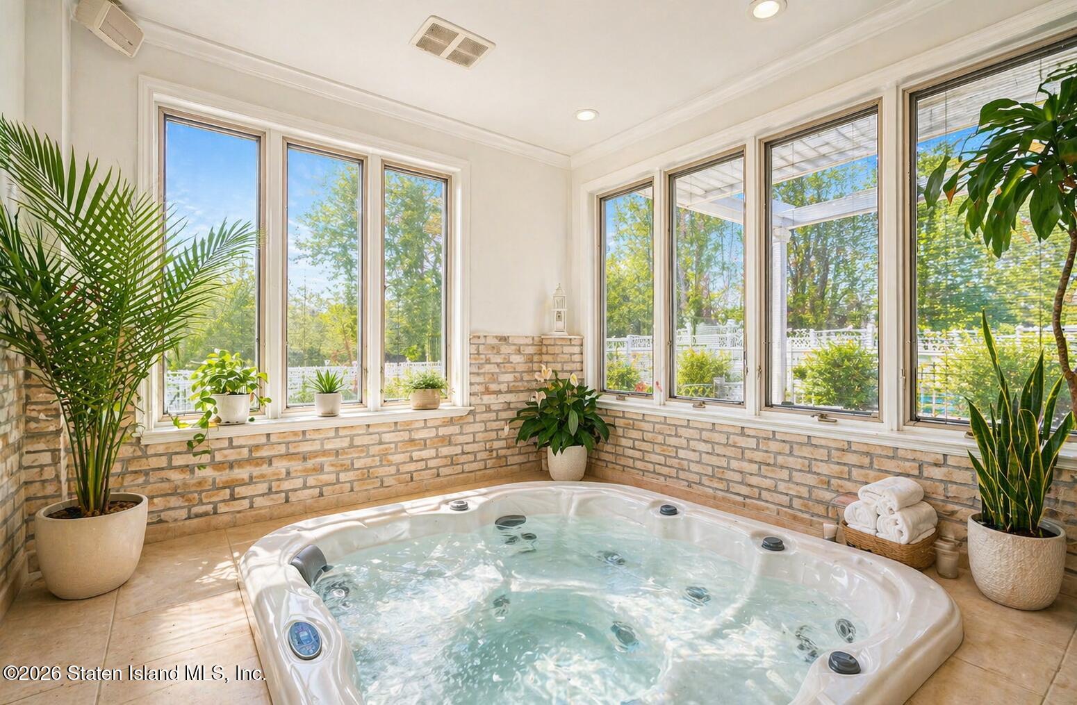 26 Highpoint Road Staten Island, NY 10304 - Photo 20 of 49 a bath tub sitting in a bathroom next to a large window