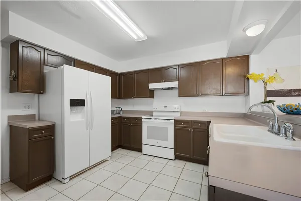 a view of a hallway with wooden floor and a bathroom