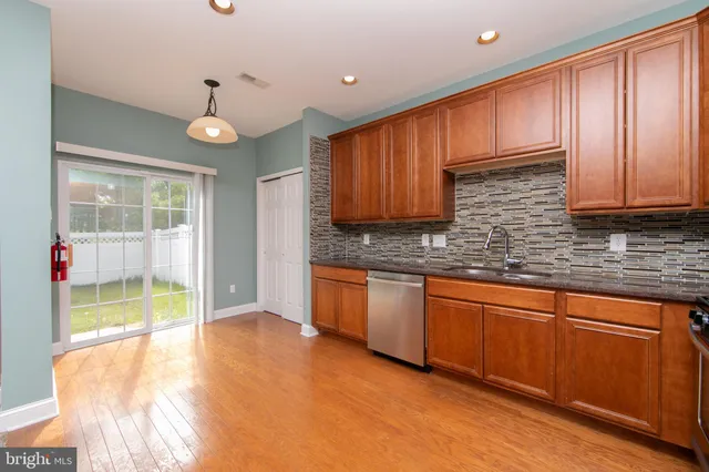 a kitchen with granite countertop wooden cabinets a sink and a stove