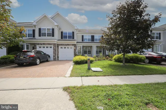 a front view of a house with a yard and a garden