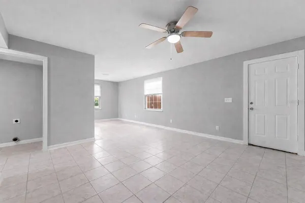 a view of a room with wooden floor white walls and a ceiling fan