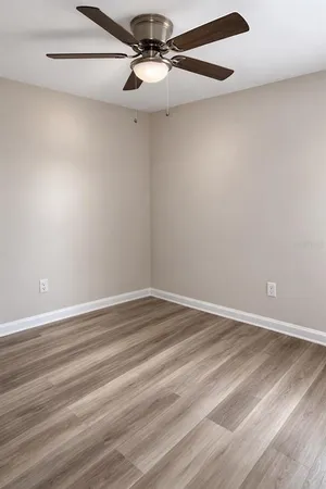 an empty room with a window and ceiling fan