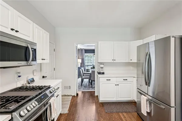 a kitchen with white cabinets and stainless steel appliances