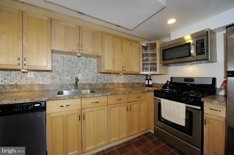 1514 17th Street Northwest, Unit 14 Washington, DC 20036 - Photo 7 of 16 a kitchen with stainless steel appliances granite countertop a stove a sink and a microwave