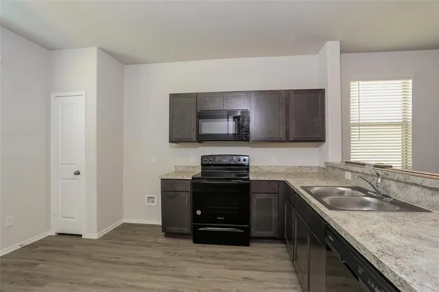 a kitchen with granite countertop a stove and a sink