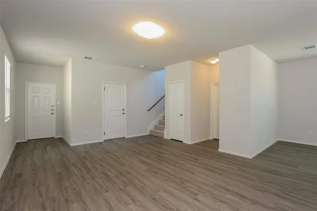 a view of an empty room with wooden floor