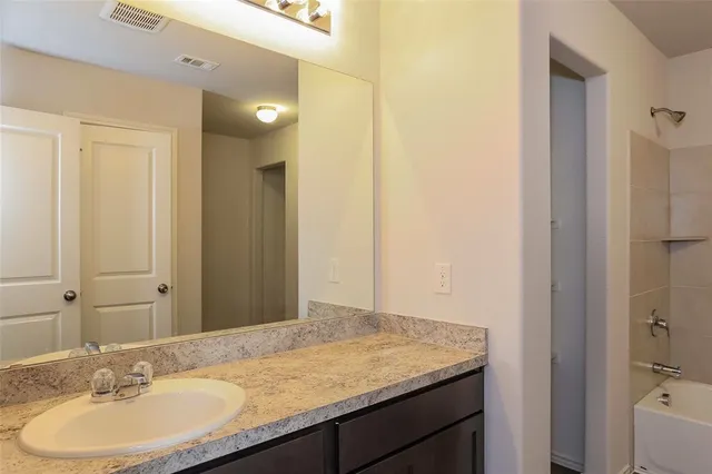 a bathroom with a granite countertop sink and a mirror