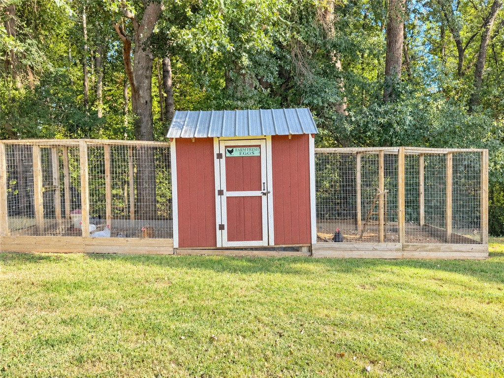 2420 Rainey Road Starr, SC 29684 - Photo 32 of 36 A charming chicken coop sits nested against a mature wooded backdrop.