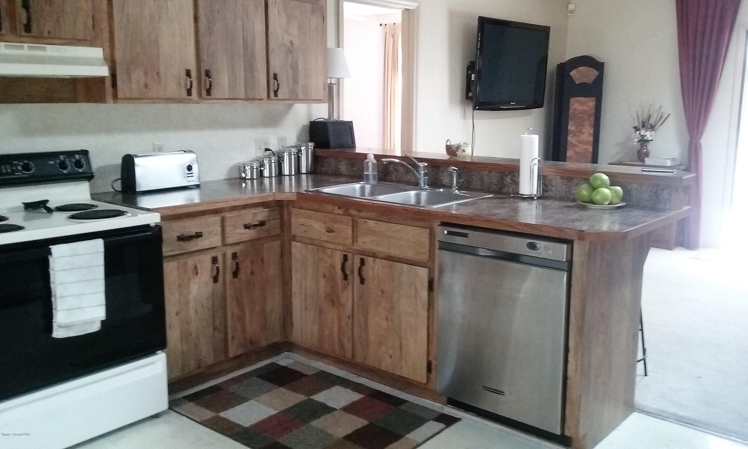 109 Tudor Road Southwest Palm Bay, FL 32908 - Photo 3 of 15 a kitchen with stainless steel appliances granite countertop a sink stove and refrigerator